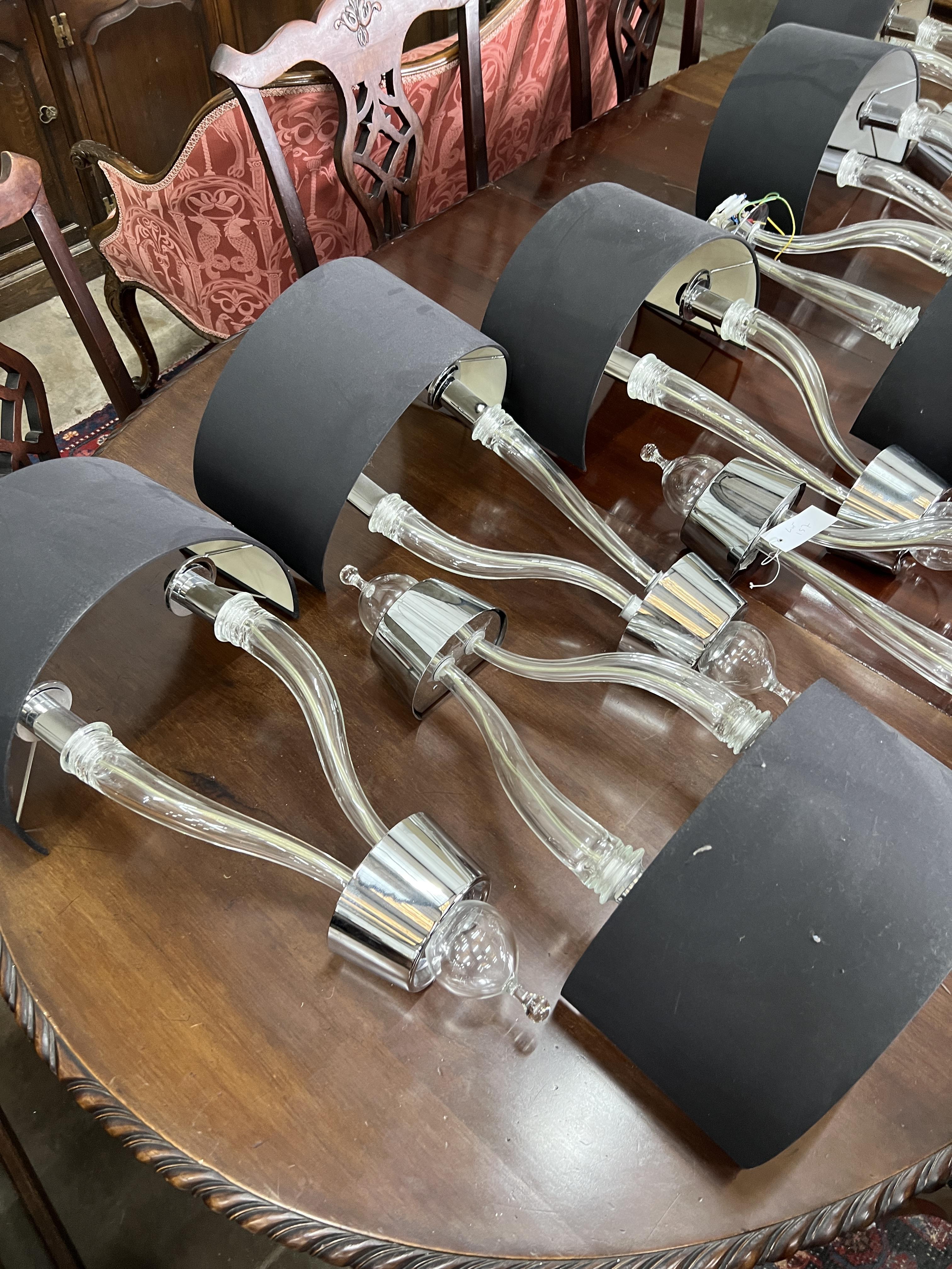 A set of ten contemporary glass and chrome two branch wall lights